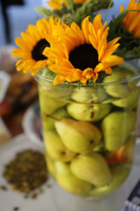 vase filled with pears and sunflowers coming from vase