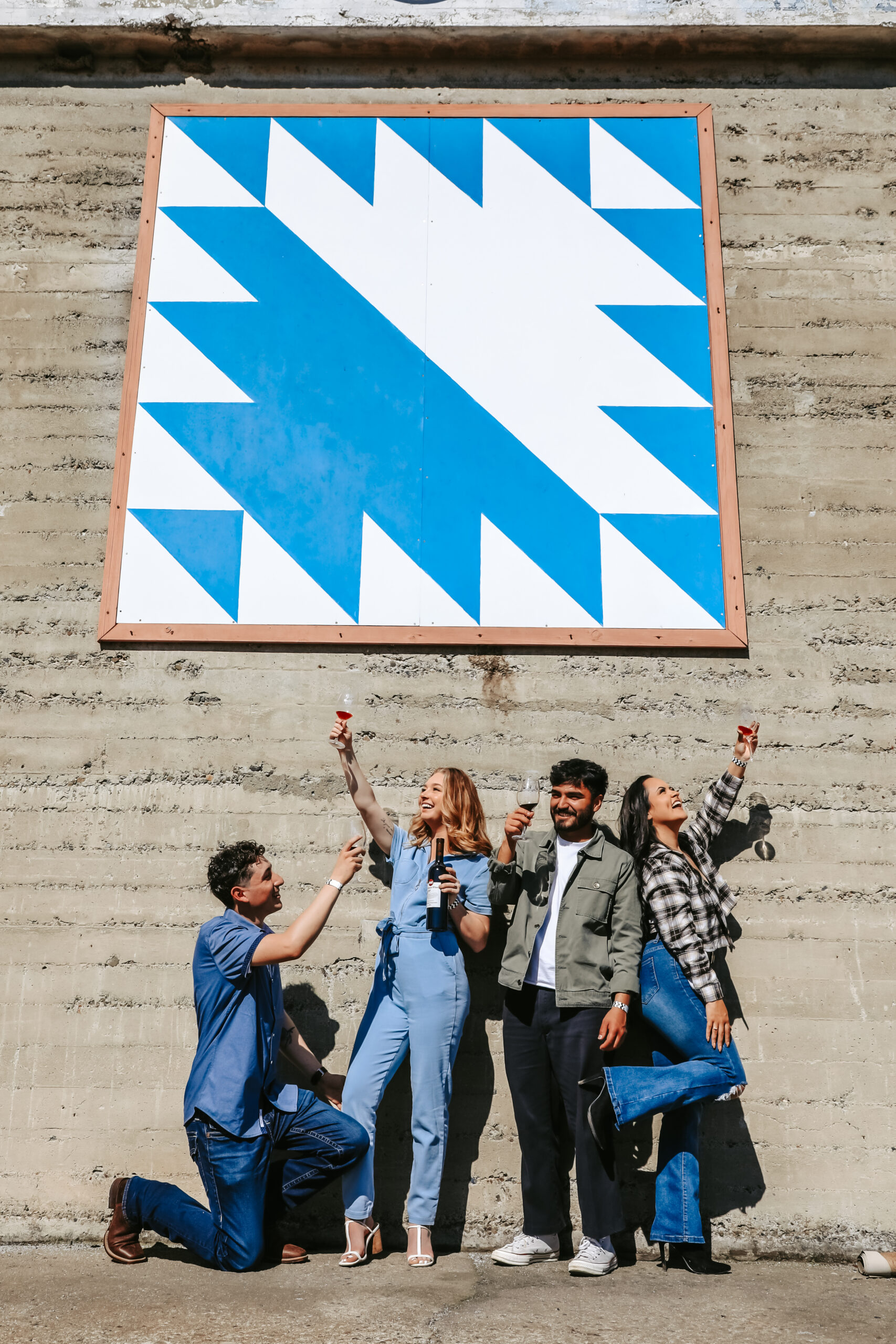 four people cheering with wine glasses